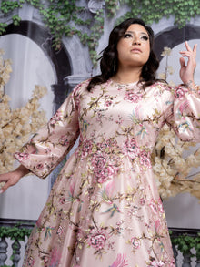  Plus size woman wearing a light pink modest gown with a floral and bird print.