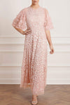 Woman wearing modest Needle & Thread Aurelia Gown in pink strawberry icing color. The gown is adorned in light pink sequin detailing and has three-quarter flare sleeves.