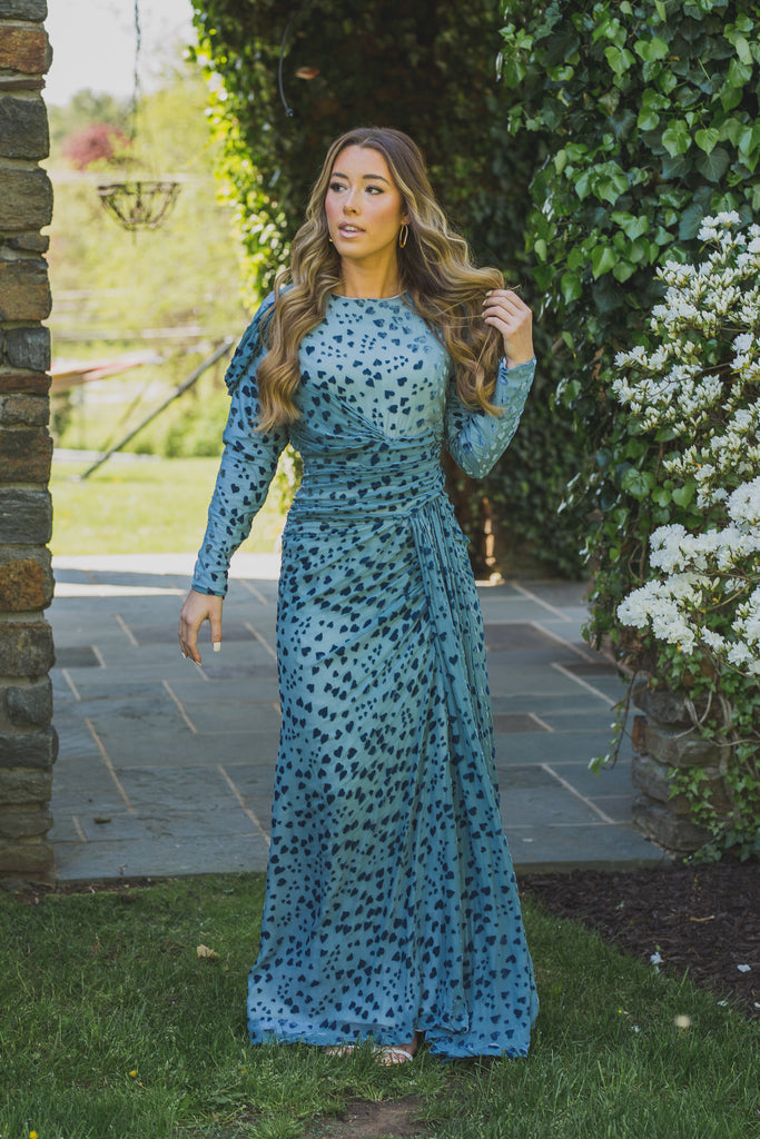 Women wearing modest blue gown with velvet heart details. The rich teal color and plush velvet texture add a luxurious and romantic touch to the dress, while the heart details add a playful and feminine touch.