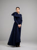 A woman wearing a modest navy lace gown with  long sleeves. The gown features a large bow on one shoulder. 