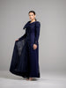 A woman wearing a modest navy lace gown with  long sleeves. The gown features a large bow on one shoulder. 