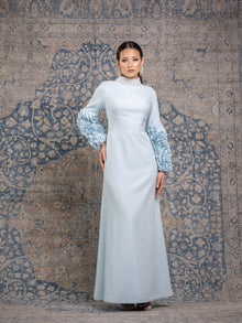  Woman wearing a modest powder blue gown with ruffled sleeves and a high neck pearl collar.