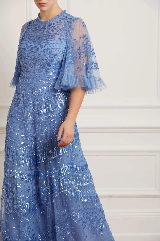 Woman wearing blue modest Needle & Thread with flare sleeves and beaded embellishments.